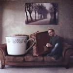 одинокий мужчина с книгой и чашкой на диване