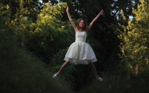 девушка в белом платье прыгает