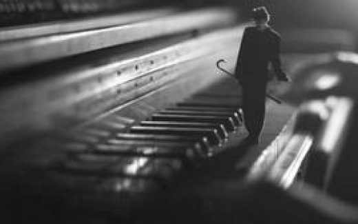 мужчина шагает по клавишам рояля