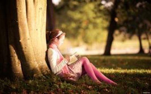 девочка читает книгу в парке