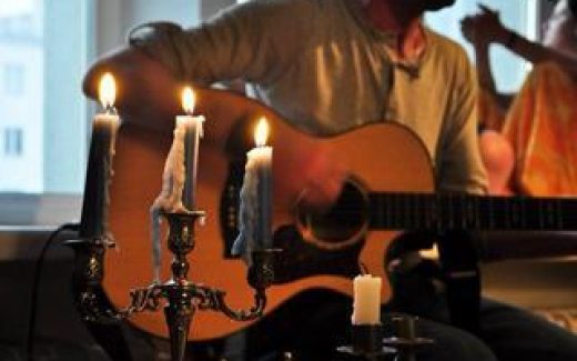 гитарист играет при свечах