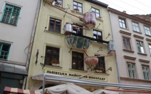 фасад "Мастерской шоколада" во Львове с инсталляцией с ваннами и трубами