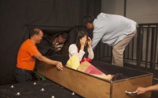 атракцион в Китае, человека укладывают в гроб