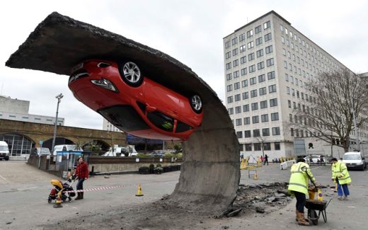 автомобиль повис на куске асфальта - инсталляция