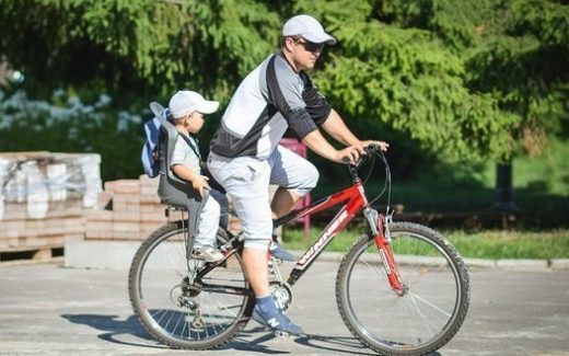 участники велоквеста: мужчина с ребенком на велосипеде